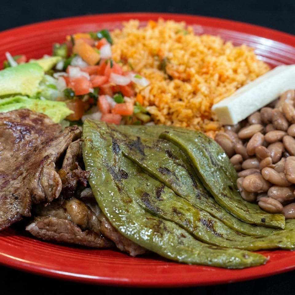 Mexican platter with grilled steak, nopales, pinto beans, rice, avocado, pico de gallo, and a tortilla on a red plate.